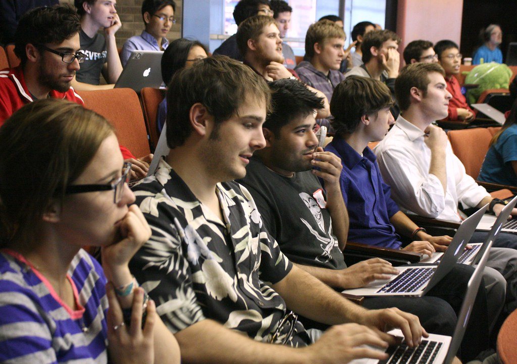 Students working on laptops at a collegiate hackathon
